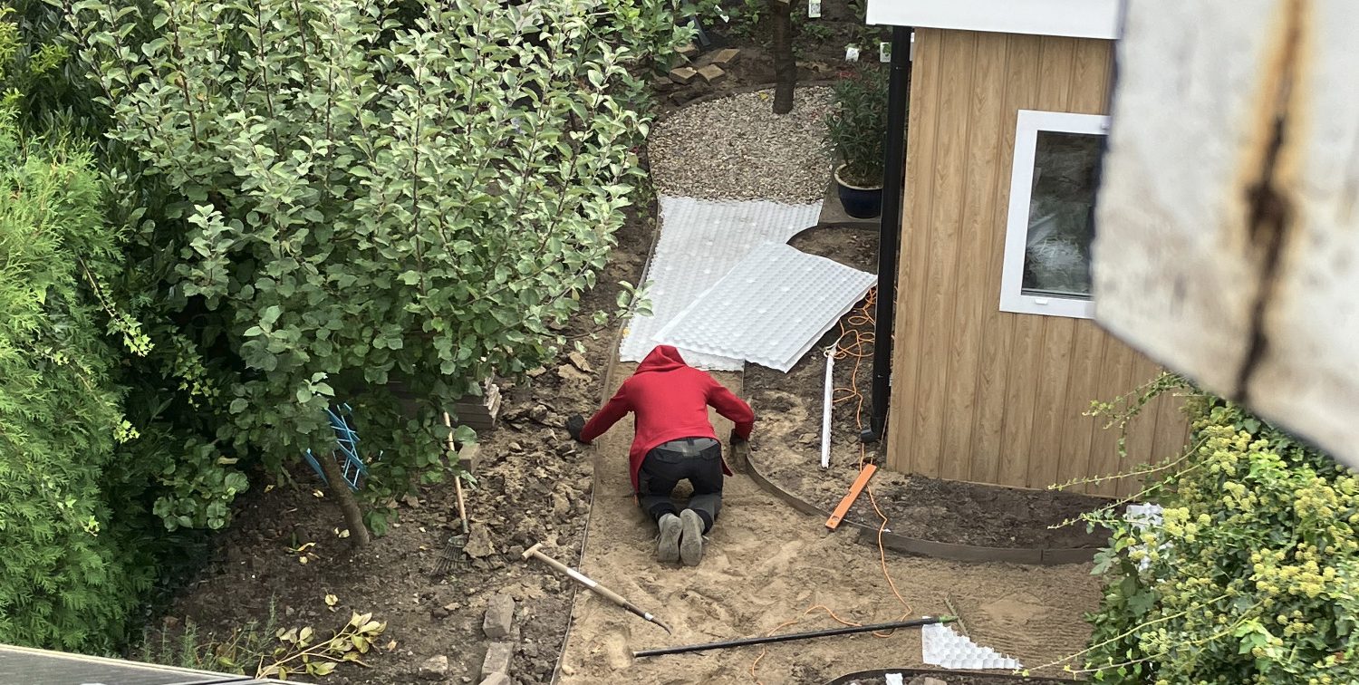 Paul Naus legt een tuinpad aan